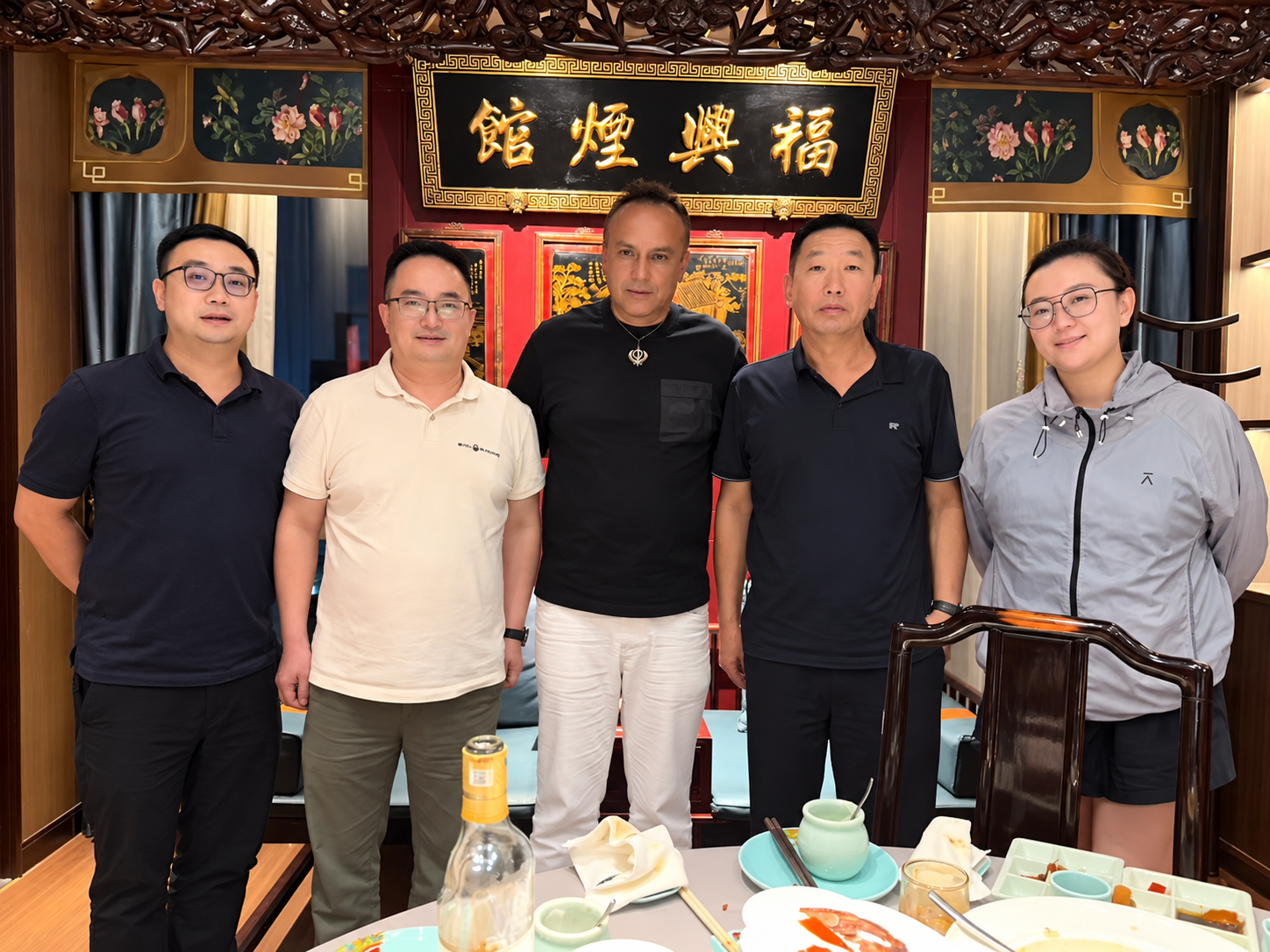 An international guest and local hosts after a meal in China